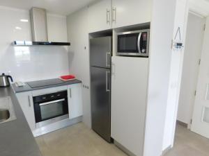 a kitchen with a refrigerator and a microwave at GMID IMMO Apartamento Oasis in Roses