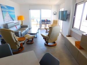 een woonkamer met een bank en stoelen bij GMID IMMO Apartamento Oasis in Roses