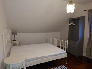 ein kleines Schlafzimmer mit einem weißen Bett und einem Tisch in der Unterkunft Mazurskie Siedlisko Langen in Mrągowo