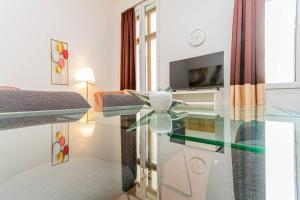a living room with a glass table in a room at Gozsdu Charming Suite by NeWave Apartments in Budapest