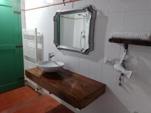 baño con lavabo y espejo en la pared en Il Sole alla Terra, en Terricciola