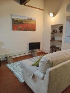 a bedroom with a bed and a television in it at Il Sole alla Terra in Terricciola