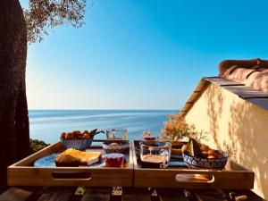 ein Tablett mit Essen auf einem Tisch mit dem Meer im Hintergrund in der Unterkunft Eufonia del Mare in Finale Ligure