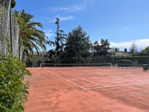 a tennis court with a net on top of it at Appartement 2 pièces Antibes Mer - Piscine, Parking, Tennis, Wifi… in Antibes