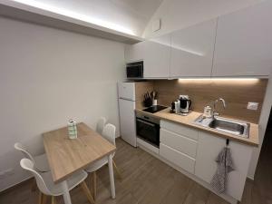 a small kitchen with a wooden table and a counter top at Appartement 2 pièces Antibes Mer - Piscine, Parking, Tennis, Wifi… in Antibes