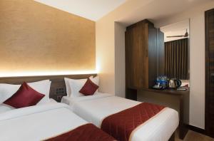 a hotel room with two beds and a cabinet at SUPREME STAY in Chennai