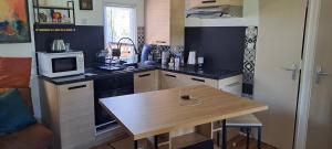 a kitchen with a wooden table and a microwave at Chez Nat in Rocbaron