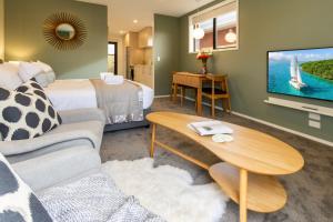 a living room with a couch and a tv at Luxury Escape for 2, Single Level Studio, Papanui in Christchurch