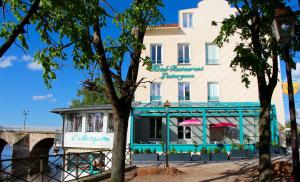 a building next to a river with a bridge at Hôtel L'Esturgeon in Poissy