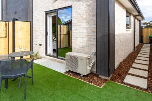 a small backyard with green grass and a house at Luxury Escape for 2, Single Level Studio, Papanui in Christchurch