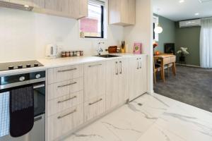 基督城的住宿－Luxury Escape for 2, Single Level Studio, Papanui，厨房配有白色橱柜和炉灶烤箱。