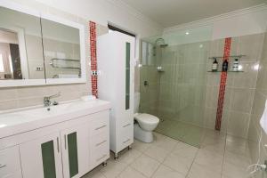 a bathroom with a sink and a toilet and a shower at Laundry Lane Cottage in Stroud