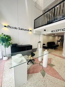 a lobby with a glass table in a room at PICCOLO SUKHUMVIT HOSTEL in Bangkok