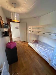 a room with two bunk beds and a wooden floor at Lilla Ridhuset in Löddeköpinge