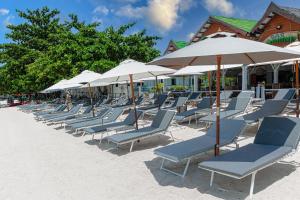 una fila de sillas y sombrillas en una playa en Bay Beach Resort, en Choeng Mon Beach