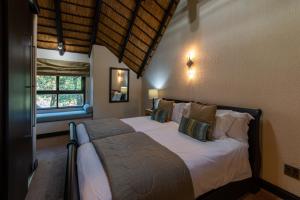 a bedroom with a large bed with white sheets and pillows at Kruger Park Lodge Unit No. 209 in Hazyview