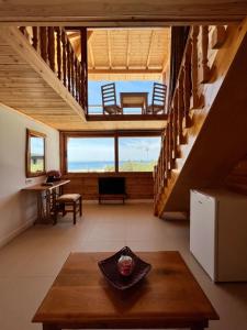 a living room with stairs and a table at Nashos Bungalows in (( Spile ))