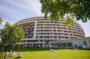 a large building with people sitting in chairs in front of it at ‘Good Feelings’ in Siófok