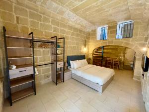a bedroom with a bed in a brick room at Ta Pinu Guesthouse in Għarb