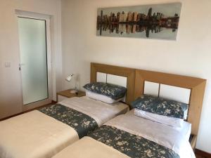two beds in a small room with a mirror at Casa do Manuel Maria in Estreito da Calheta