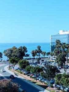 a parking lot with cars parked in front of the ocean at Diana Apartment in Limassol