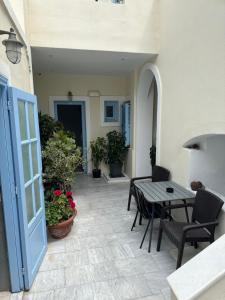 um pátio com uma mesa e cadeiras e uma porta em Villa Roussa em Fira