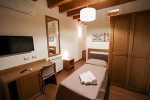 a bedroom with a bed and a desk and a television at Camere U Campanaru in Gratteri