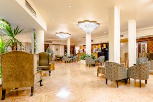 a lobby with chairs and tables and chandeliers at The Grand Hotel, Hurghada in Hurghada