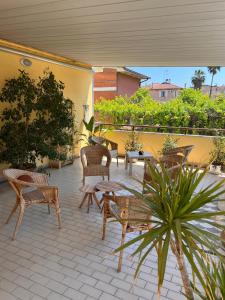 a patio with wicker chairs and tables on a patio at Ubika Hotel in Porto San Giorgio