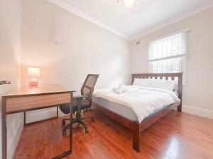 a bedroom with a desk and a bed and a desk at Pyrnmont Terrace & Townhouse in Sydney