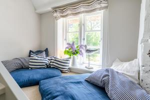 a bedroom with blue and white pillows and a window at Green Wening in Borgsum