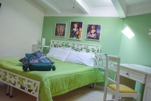 グラヴィーナ・イン・プーリアにあるB&B Santa Sofiaの緑の壁のベッドルーム1室
