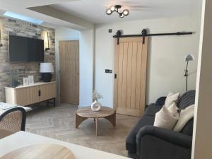 a living room with a couch and a tv at Greensfield Close 