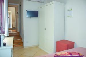 グラヴィーナ・イン・プーリアにあるB&B Santa Sofiaの白いキャビネット(テレビ付)が備わる客室です。