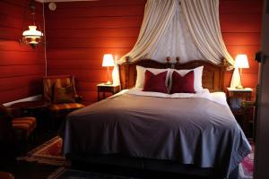 瓦爾達爾的住宿－Sylte Hotell, Valldal，一间卧室设有一张带红色墙壁的大床