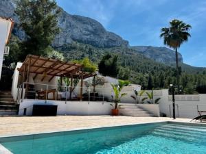 a house with a swimming pool and mountains in the background at House with swimming pool and amazing sea and mountain views in Montgó, Denia in Denia