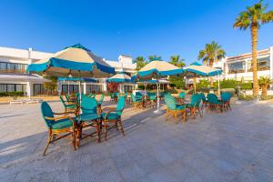 The Grand Hotel, Hurghada في الغردقة: مجموعة كراسي وطاولات مع مظلات