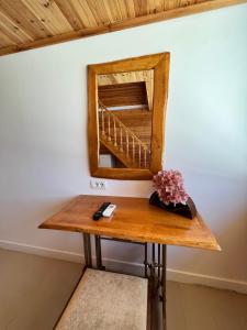 a wooden table with a mirror on a wall at Nashos Bungalows in (( Spile ))