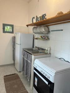 een keuken met een fornuis en een koelkast bij Villa Zefiro - Campomarino di Maruggio in Campomarino