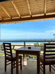 a table and chairs in a room with a view of the ocean at Nashos Bungalows in (( Spile ))