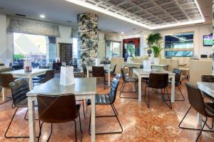 un comedor con mesas y sillas en un restaurante en Hotel Spa Milagros Golf, en Mogro