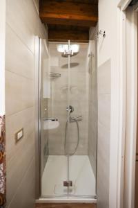 y baño con ducha y puerta de cristal. en Camere U Campanaru, en Gratteri