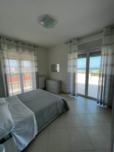 a bedroom with a bed and a view of the ocean at Nautilus Appartamenti a mare in Ortona