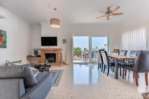 Una sala de estar con un sofá y una mesa con sillas. en Casa Leo holiday villa, en Mijas Costa