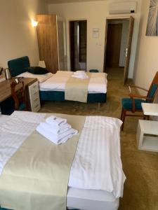 two beds in a hotel room with towels on them at Penzión Deloris in Trenčín