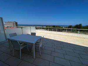 una mesa y sillas en un balcón con vistas al océano en Nautilus Appartamenti a mare, en Ortona