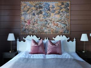 瓦爾達爾的住宿－Sylte Hotell, Valldal，挂在床上的挂着粉红色枕头的挂毯