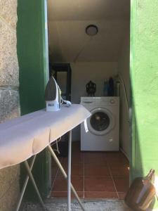 a laundry room with a washing machine in a room at Swimming pool, beach and garden in Nigran in Nigrán