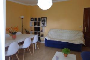 a room with a bed and a table and chairs at Swimming pool, beach and garden in Nigran in Nigrán