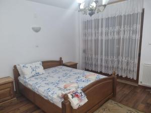 a bedroom with a bed and a window with curtains at Vila Orizont in Venus